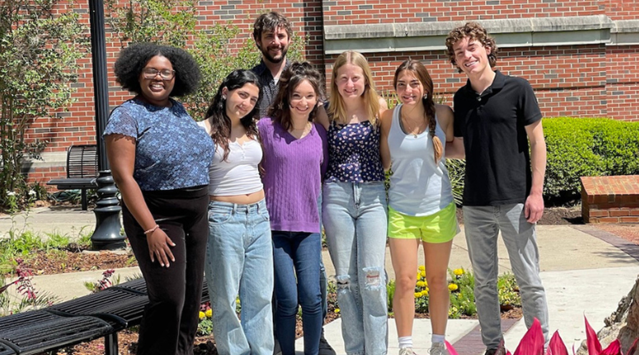 Terence Crofts’ research group, including paper co-authors Ezabelle Frank (far left), Terence Crofts (behind the group), Elizabeth Bernate (center, in purple), and Hayden Allman (far right). 