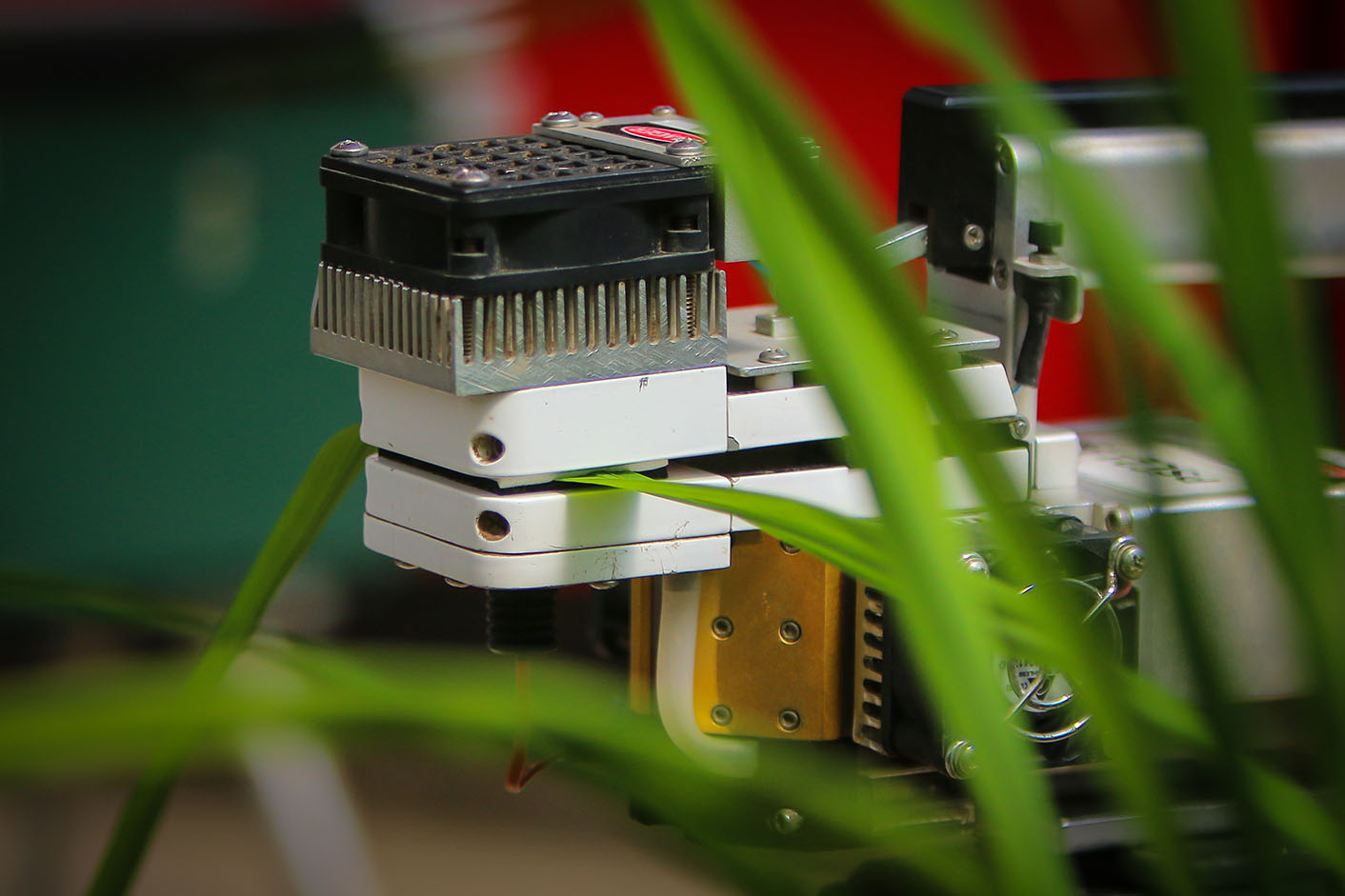 Photo of infra-red gas analyzer and a rice leaf. The leaf is placed inside a cuvette in which conditions related to light intensity, CO2 concentration, relative humidity, and temperature can be controlled. 